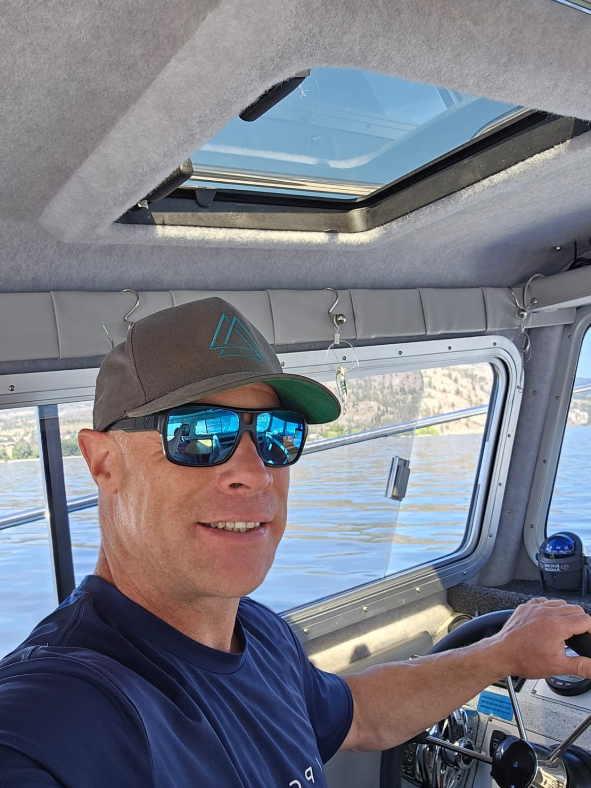 Captain Dennis Barnes at the helm of the Kingfisher 2525 on Okanagan Lake