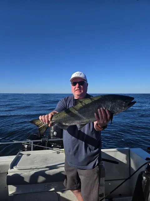 Guest holding a big chinook salmon on the open Pacific